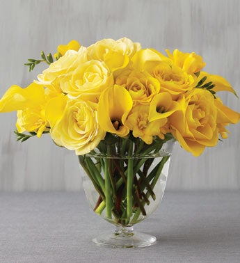 yellow bouquet in scrolled glass vase